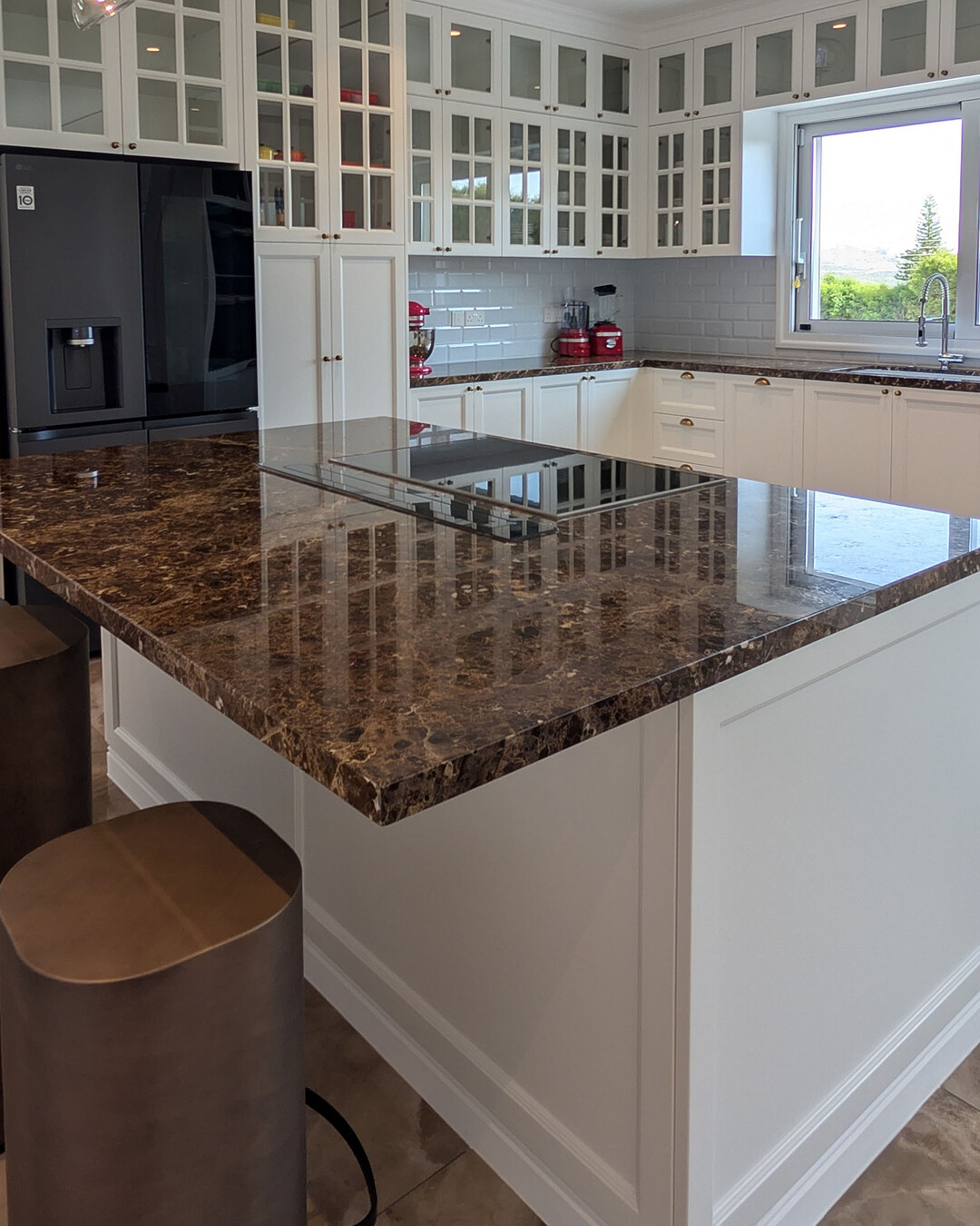 Kitchen with glass-fronted cabinets and a dark marble island