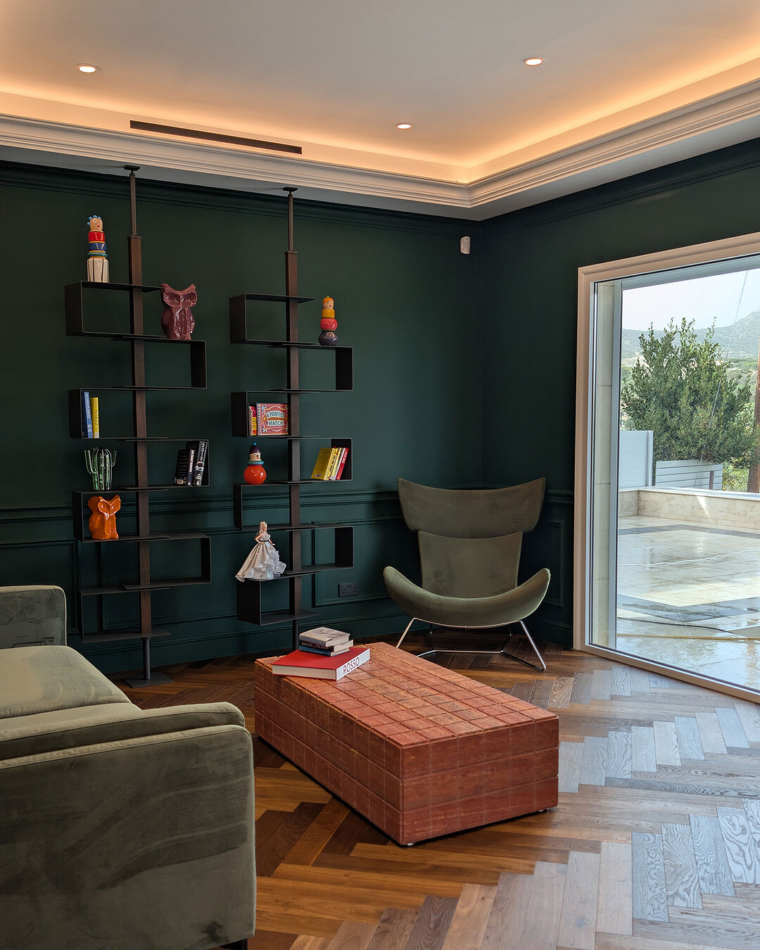 Den with deep green panelled walls